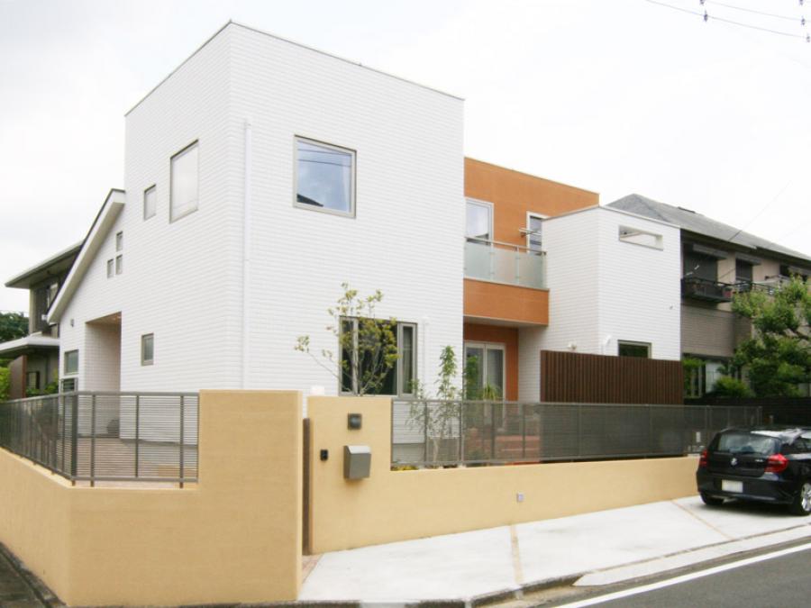 白とオレンジのツートンカラーのデザイン住宅